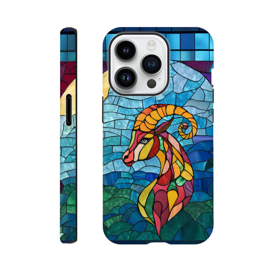 iPhone case featuring a vibrant stained-glass mosaic art illustration of a Capricorn sea-goat. The design shows the goat's head and upper body in segmented colors of red, orange, yellow, and green, against a background of blues and greens resembling water and sky, with dark separating lines.