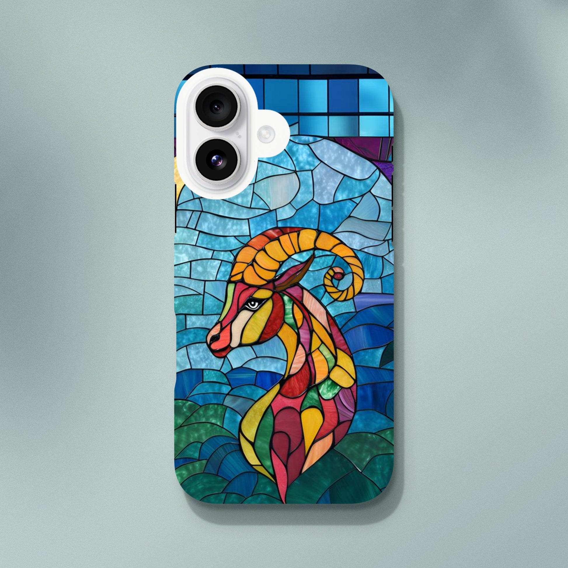 iPhone case featuring a vibrant stained-glass mosaic art illustration of a Capricorn sea-goat. The design shows the goat's head and upper body in segmented colors of red, orange, yellow, and green, against a background of blues and greens resembling water and sky, with dark separating lines.